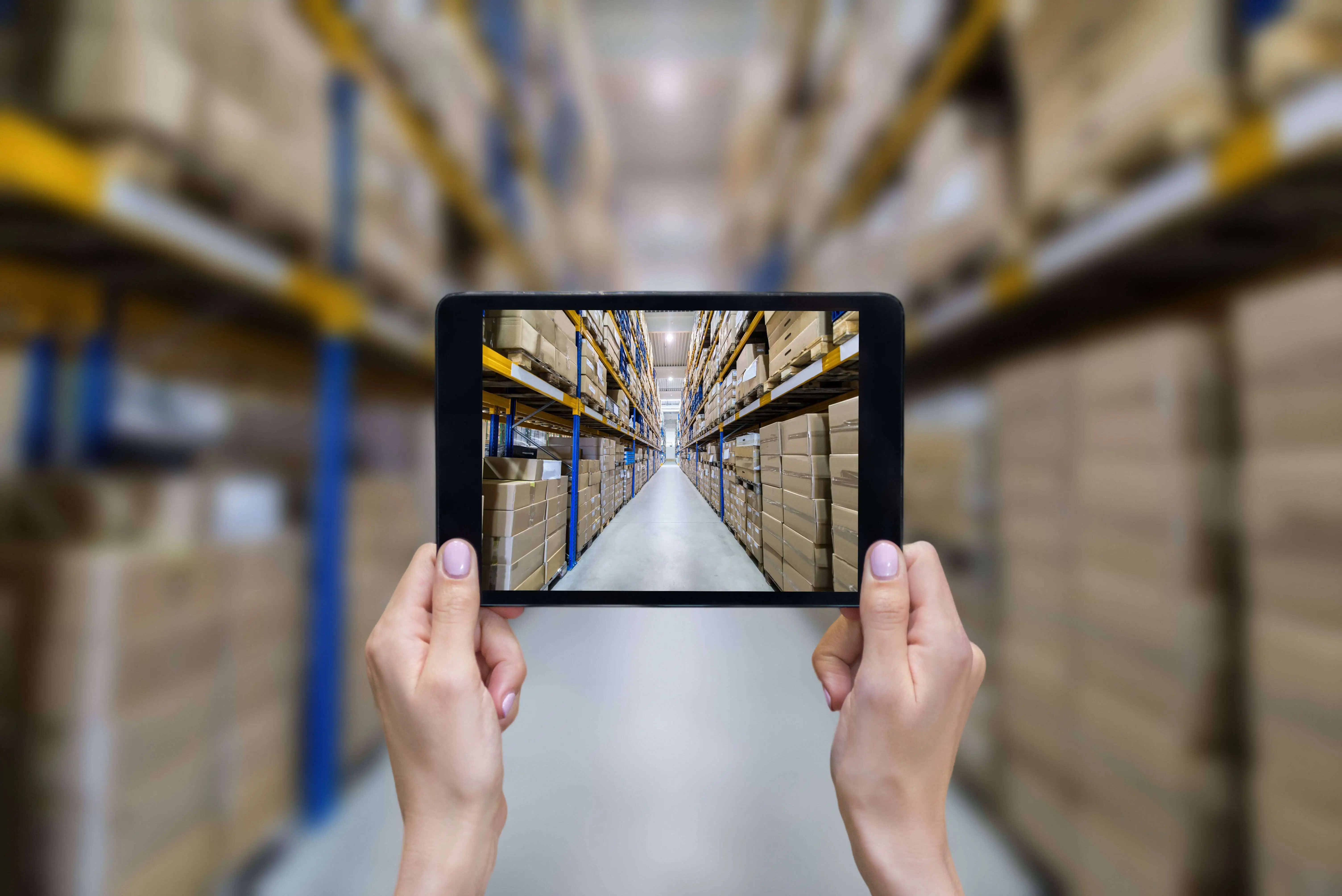 looking at a warehouse through the screen of a tablet